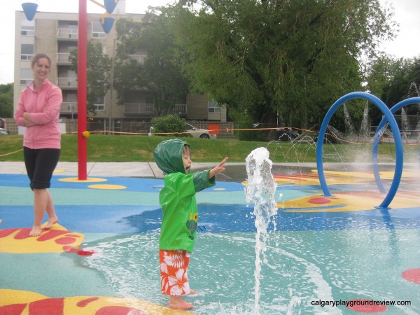 Kid playing in Calgary's rotary park spray park in the rain