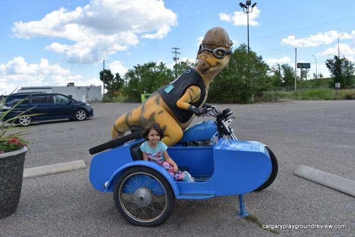 Dinosaur driving a motorcycle statue - Drumheller With Kids